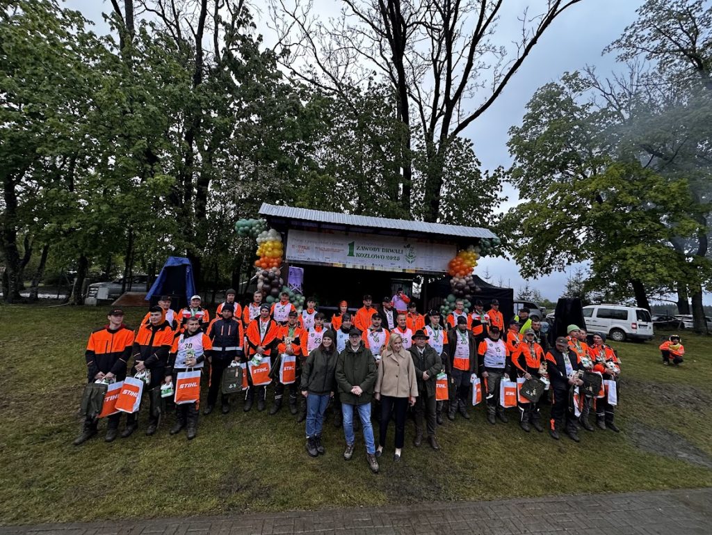 Na zdjęciu widzimy wszystkich uczestników zawodów, pozujących do wspólnego zdjęcia, prawdopodobnie po zakończeniu wszystkich konkurencji.