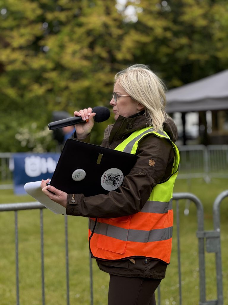 Na zdjęciu widzimy kobietę, która podczas drugiego dnia zawodów była spikerem i opowiadała publiczności o kolejnych konkurencjach zawodów drwali.